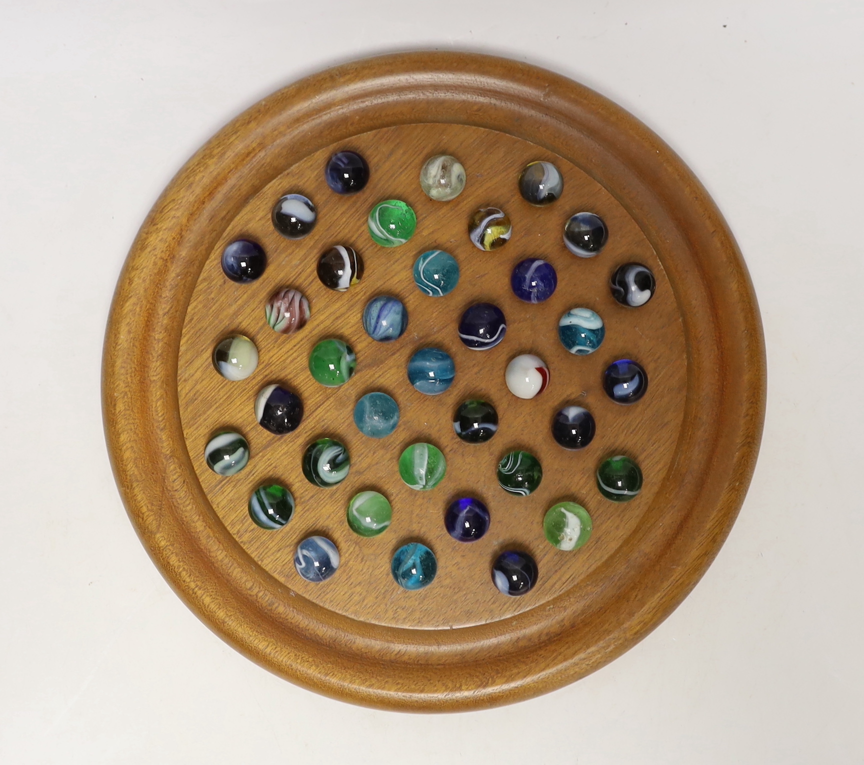 A solitaire board with glass marbles, board 25cm in diameter